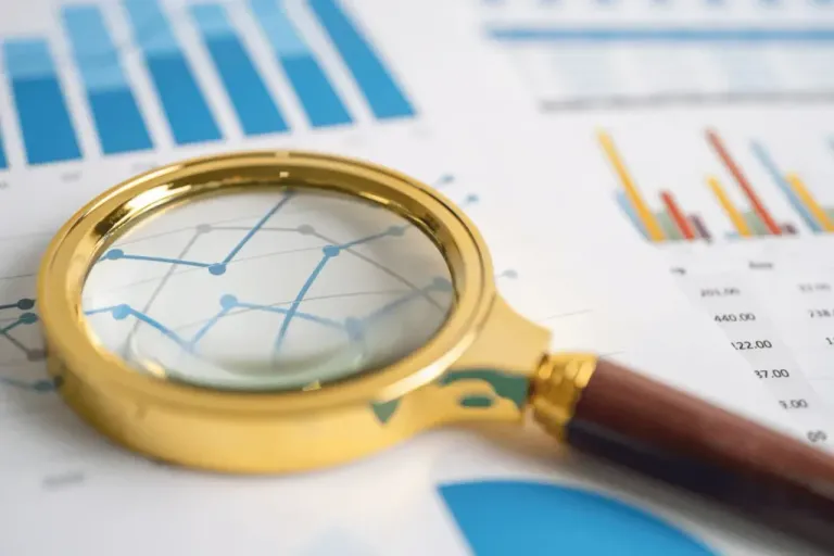 Magnifying glass examining business data charts illustrating a software delivery diagnostic
